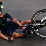 Cyclist falls during race, lying on the road.