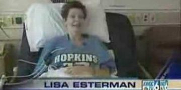 Smiling patient in hospital bed with Hopkins shirt.