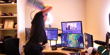 Gamer angrily smashing keyboard on stream setup.