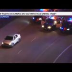 Police cars surround vehicle on nighttime road.