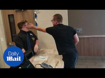 Man slapping another man in hotel lobby