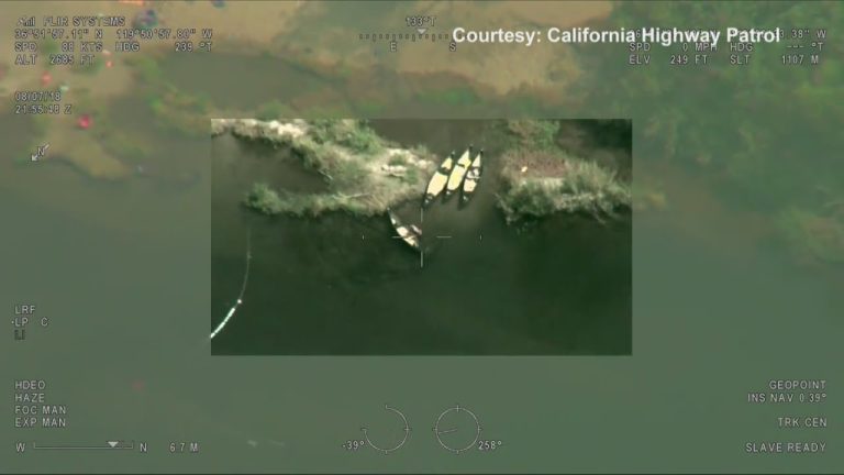 Aerial view of boats on riverbank.