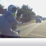 Motorcyclist on busy road with cars.