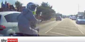 Motorcyclist on busy road with cars.