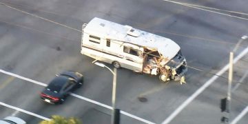 Damaged RV chased by police car on street