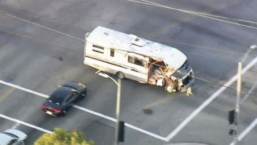 Damaged RV chased by police car on street