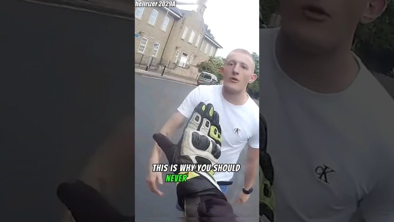 Motorcyclist gesturing towards a man on the street.