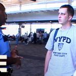 Police officer talking to travelers at airport.