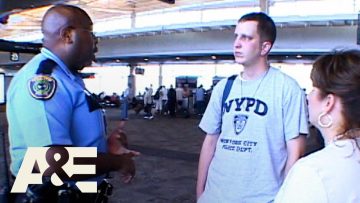 Police officer talking to travelers at airport.