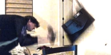 Man frustrated throwing a computer monitor.