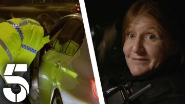 Police officer checks car at night scene