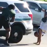 Person doing handstand near police car