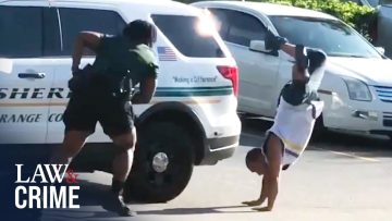 Person doing handstand near police car