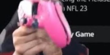 Person holding pink gaming controller.