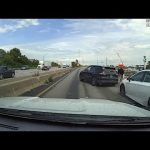 Highway accident scene with multiple cars involved.