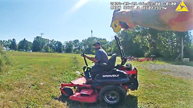 Person operating lawn mower in a field