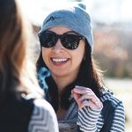 Smiling woman in sunglasses and gray beanie