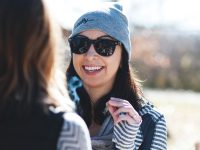 Smiling woman in sunglasses and gray beanie