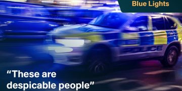 Police car with blue lights speeding at night