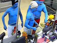 Three blue-painted people at a store checkout