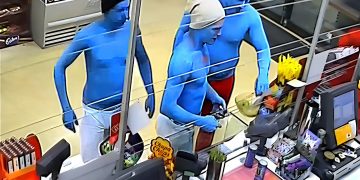 Three blue-painted people at a store checkout