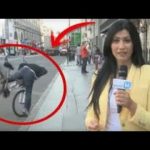 Reporter unaware of cyclist falling in background.