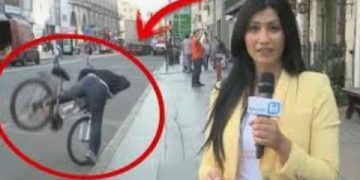 Reporter unaware of cyclist falling in background.