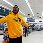 Person in yellow hoodie excited in store.