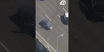 Car driving on highway during police pursuit.