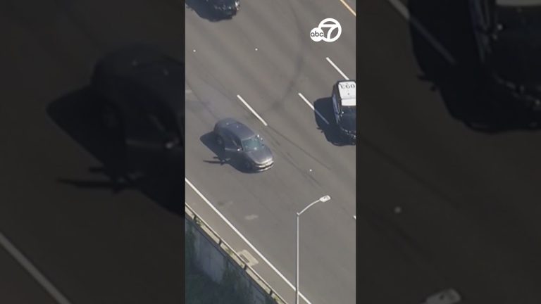 Car driving on highway during police pursuit.