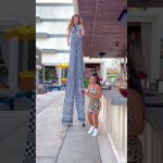 Tall performer on stilts entertaining at outdoor bar