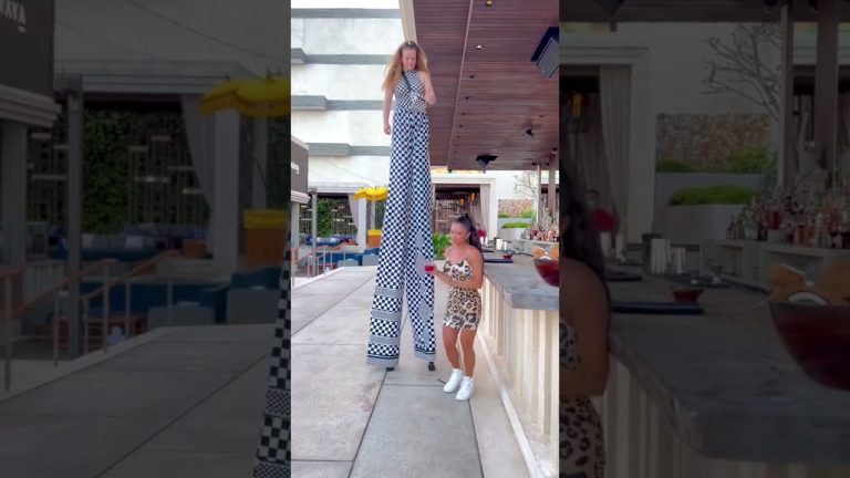 Tall performer on stilts entertaining at outdoor bar