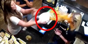 Woman throws food at another in restaurant.