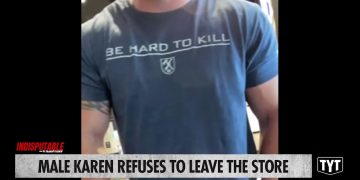 Man in store with 'Be Hard To Kill' shirt.