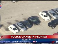 Police chase in Miami parking lot, aerial view.