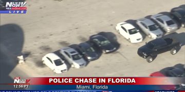 Police chase in Miami parking lot, aerial view.