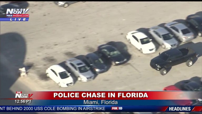 Police chase in Miami parking lot, aerial view.