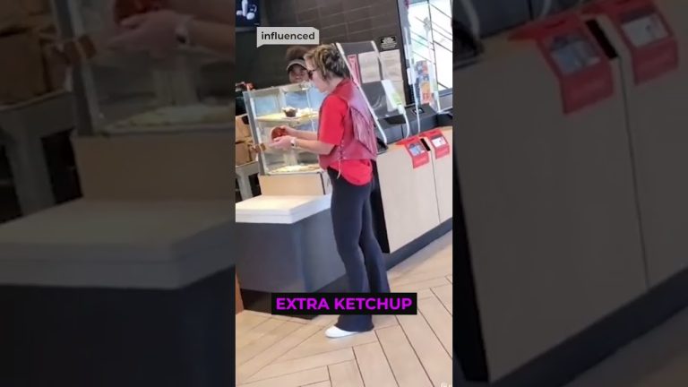 Woman holds ketchup in fast-food restaurant.