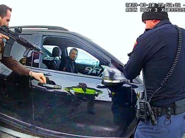 Police officers inspecting car during traffic stop.