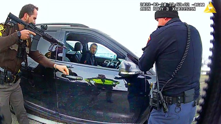 Police officers inspecting car during traffic stop.