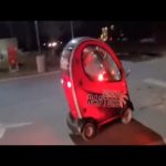 Small red car driving at night