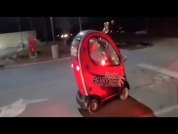 Small red car driving at night