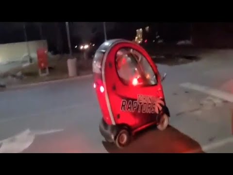 Small red car driving at night