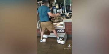 Person standing in McCafé area, wearing tray shoes.