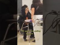 Student in classroom with peers confronts standing classmate.