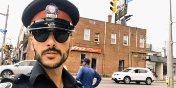 Police officer on city street corner.