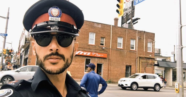 Police officer on city street corner.