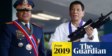 Two men with medals and rifle, 2019 event.