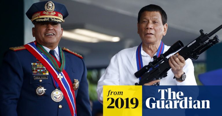 Two men with medals and rifle, 2019 event.