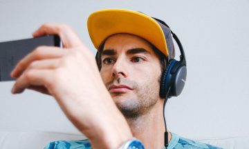 Person wearing headphones, using a smartphone.